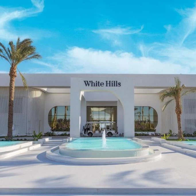 Білий фасад, пальми й басейн біля входу до Sunrise White Hills у Шарм-ель-Шейху